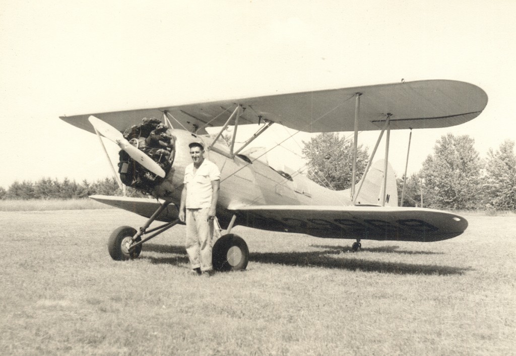 Bob Green, a local farmer who flew B-24 bombers in WWII, with his Waco UPF-7 at Brodhead Airport. Early 1960s.
