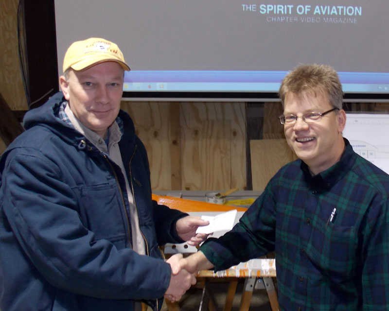 Mike Weeden, president of Cheeseland Chapter EAA 431 (left) accepts check from the Kelch Charitable Trust presented by board member Bill Liimatainen.
