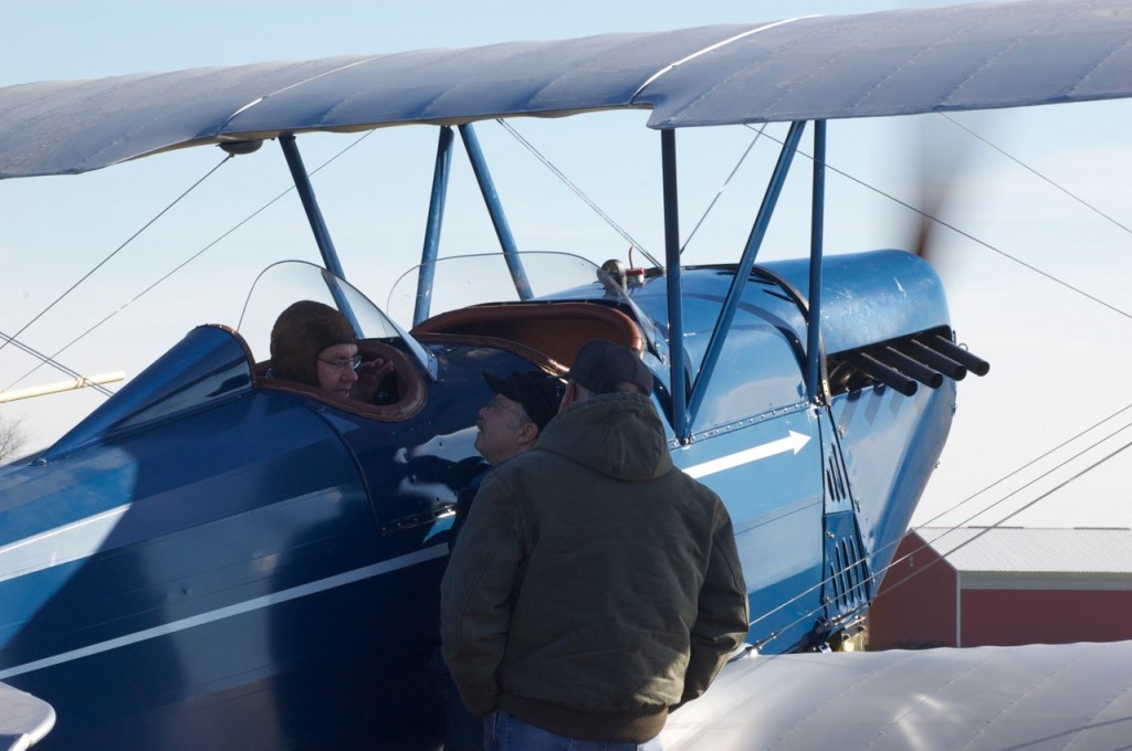 Eric Berens talks to pilot Tom Hegy while Kent McMakin looks on.